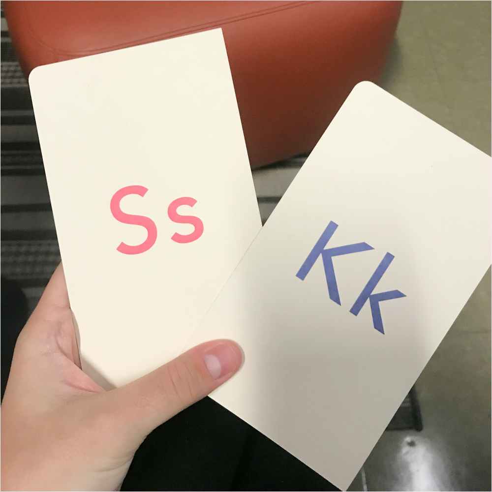 Hand holding cards with letters S and K