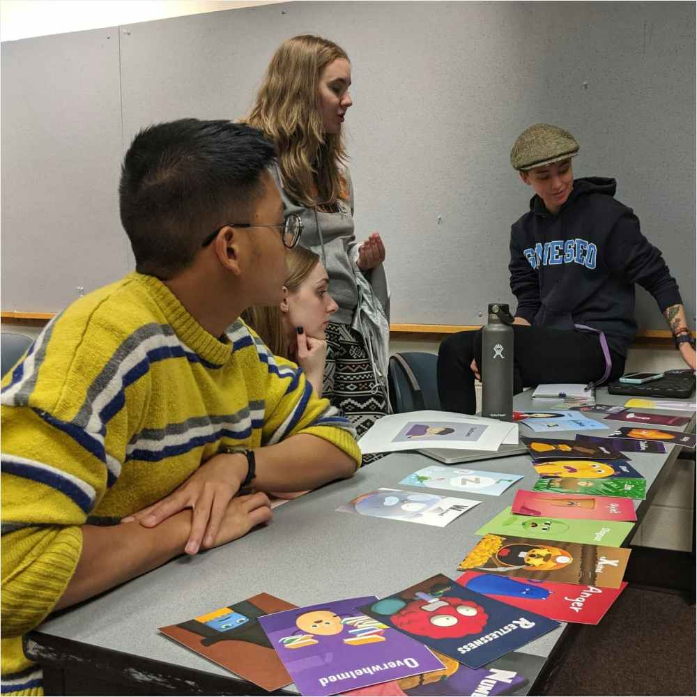 A group of students looking at cards laid out on a table