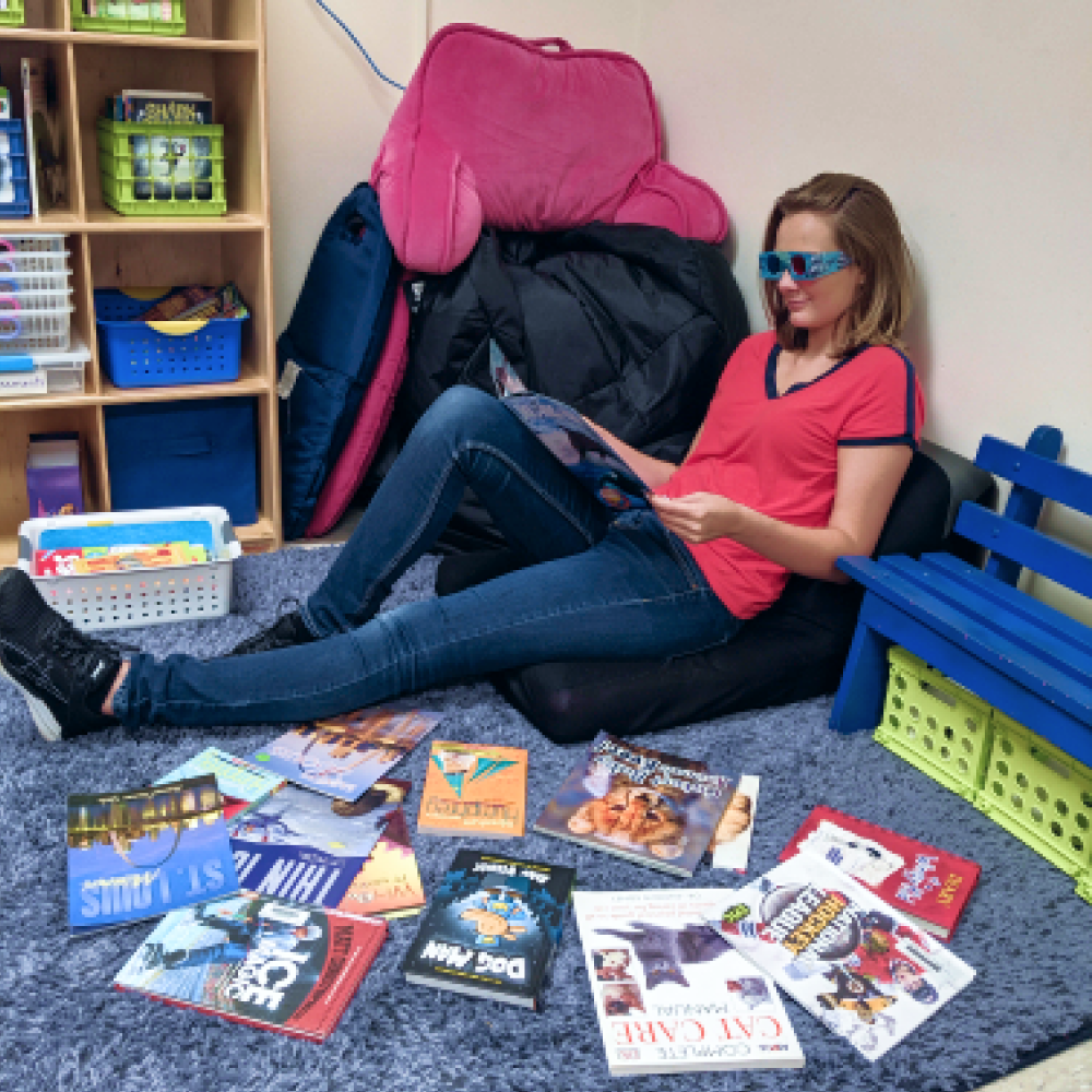 Women sitting on the ground reading children's books with 3d glasses